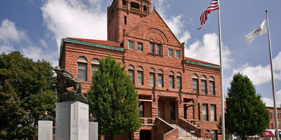 Warren County courthouse in Monmouth, IL (pop. 9,840). The current courthouse is the forth county courthouse and is a great example of Richardsonian architecture with the monumental feel and rough hewn red portage stone facade. The building was erected in 1894 and originally had a taller tower including a Seth Thomas Clock that was removed. The building also featured a statue of Lady Liberty on the front gable of the building, but the statue blew down in an 1895 windstorm and was not replaced. Part of the Monmouth Courthouse Commercial Historic District - National Register of Historic Places #05001604.