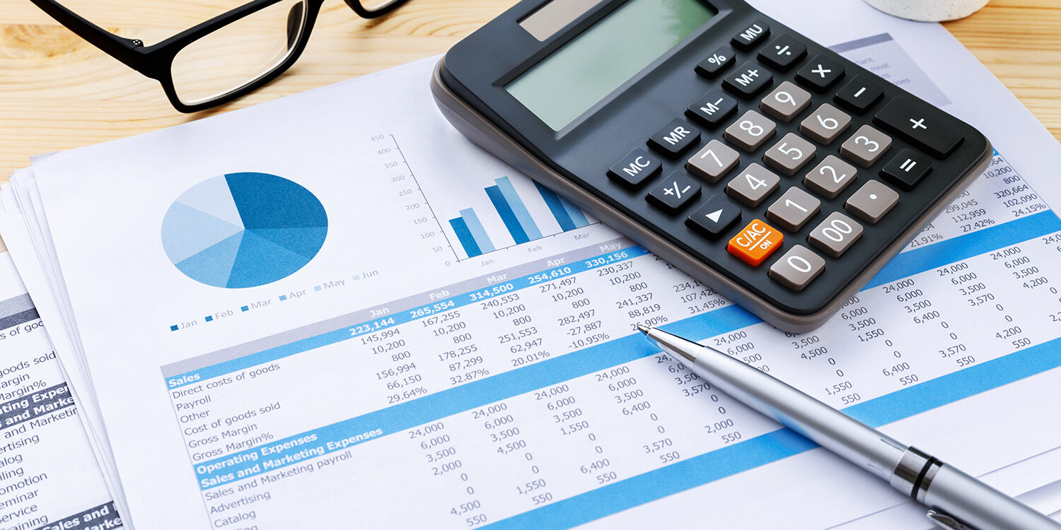 Financial chart and data with calculator and pen on wooden desk